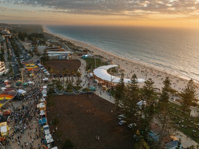 Scarborough foreshore from the air at sunset, with market stalls and a crowd