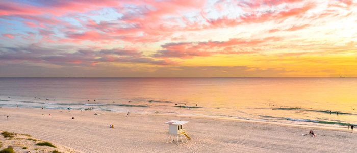 Trigg Beach at sunset: pink cloud over the water and a lifeguard tower on the sand