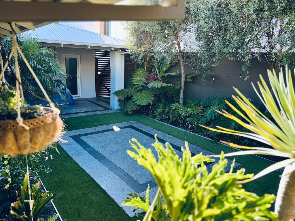 Walled garden with lawn, a paved court and the terrace of the house behind