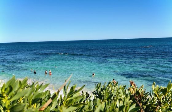 Swimmers in clear turquoise water at Mettams Pool