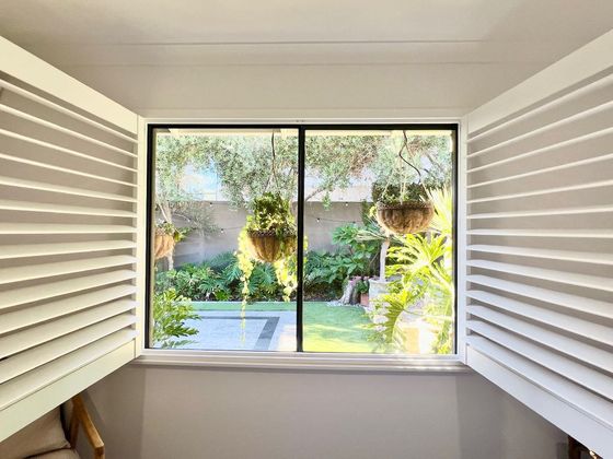 Garden seen through open plantation shutters