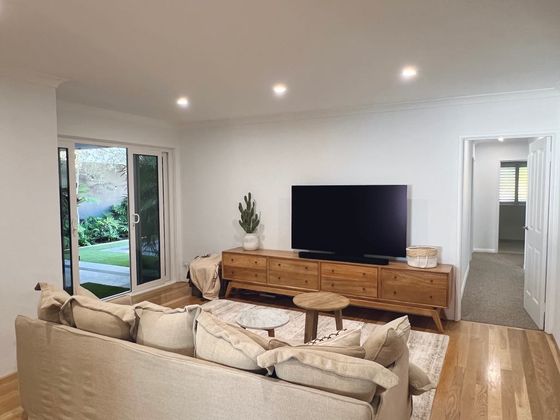 Family room with a linen sofa, television and sliding doors to the garden