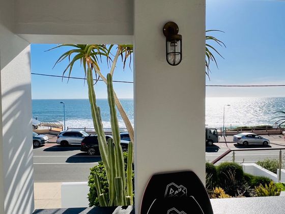 Ocean view between the porch columns with a bodyboard leaning by the door