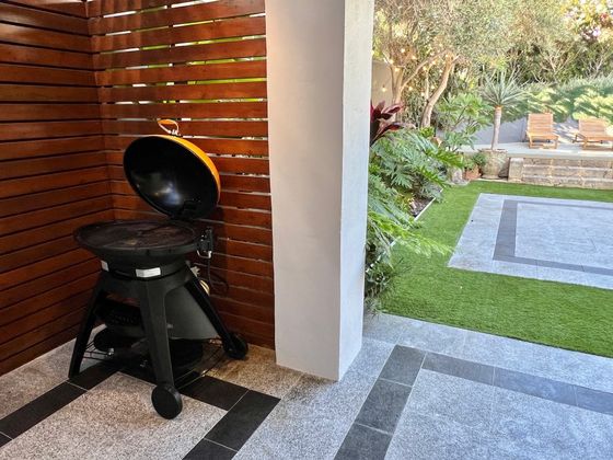 Kettle barbecue on the terrace with the lawn and sun deck beyond